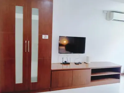 a room with a tv and a wooden cabinet at XX Yon INN Sukhumvit 4- BTS Nana in Bangkok