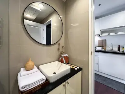 a bathroom with a sink and a mirror at Modern Cityscape1BR - Ultra Fast WiFi - BTS On nut in Bangkok