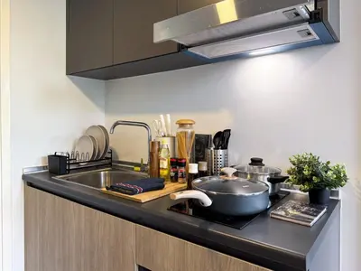 a kitchen counter with a sink and a pot on a cutting board at Serene Tropical 1BR - Ultra Fast Wifi - Sathorn in Bangkok