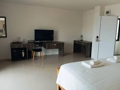 a bedroom with a bed and a desk and a television at VS Place in Nonthaburi