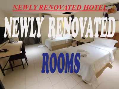 a hotel room with two beds and a desk at Hotel Soni Mansion Pratunam in Bangkok