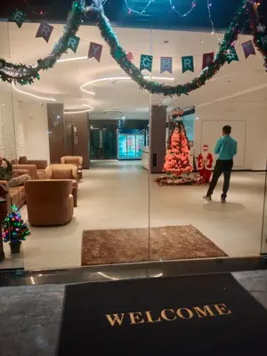 a person standing in a lobby with a christmas tree at Hotel Soni Mansion Pratunam in Bangkok