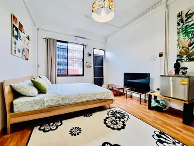 a bedroom with a bed and a flat screen tv at Gallery house 177-3min walk BTS near icon siam in Bangkok