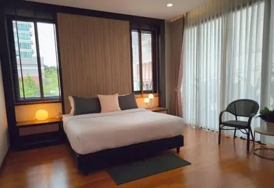 a bedroom with a bed and some windows at Studio Sukumvit 29 in Bangkok