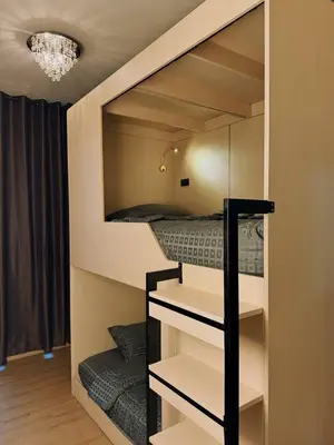 a bunk bed in a small room with a bed at Holy Hostel Sathorn in Thung Maha Mek