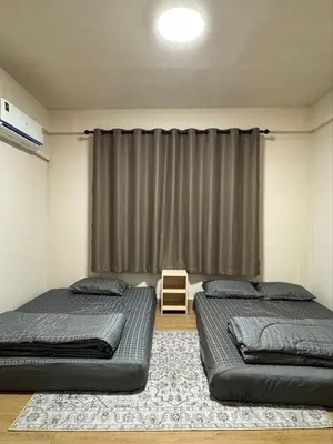 two beds in a room with a window at Holy Hostel Sathorn in Thung Maha Mek