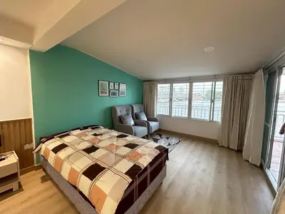 a bedroom with a bed and a chair in it at บ้านริมน้ำ bann rim num in Bangkok