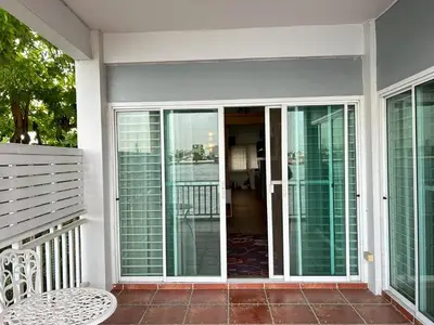 a screened in porch with sliding glass doors at บ้านริมน้ำ bann rim num in Bangkok