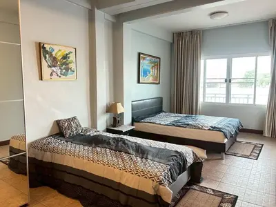a bedroom with two beds and a window at บ้านริมน้ำ bann rim num in Bangkok