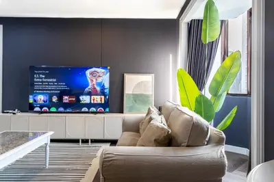 a living room with a couch and a tv at Omni Nuvél 4 Sukhumvit Branded Suites in Bangkok