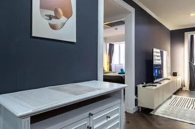 a room with a blue wall with a counter and a mirror at Omni Nuvél 4 Sukhumvit Branded Suites in Bangkok