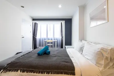 a bedroom with a large bed with a blue object on it at Omni Nuvél 4 Sukhumvit Branded Suites in Bangkok