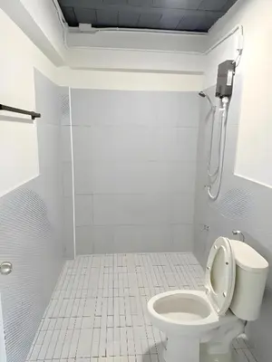 a white bathroom with a toilet and a shower at Yellow Place Sukhumvit Soi 2 -เยลโล เพลส สุขุมวิทซอย 2 in Bang Kapi