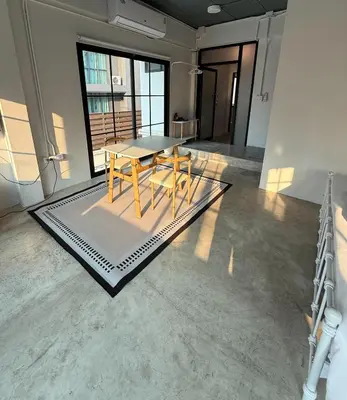 a dining room with a table and chairs on a rug at Yellow Place Sukhumvit Soi 2 -เยลโล เพลส สุขุมวิทซอย 2 in Bang Kapi