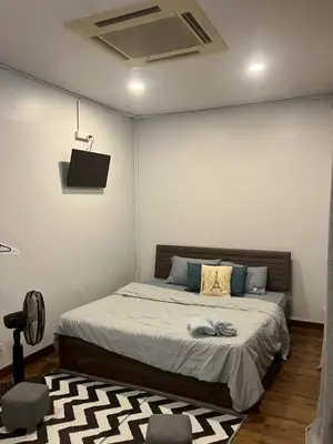 a bedroom with a bed with a television and a rug at Cat in the box homestay in Godown