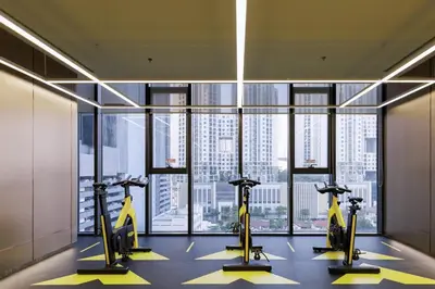 a gym with cardio machines in front of a large window at One9Five Asoke Rama 9 \u6708\u79df 500mbps wifi in Bangkok