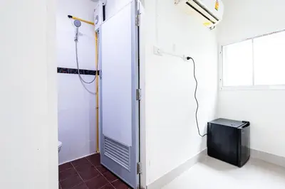 a bathroom with a shower stall and a television at XX Oh My Nap BTS Nana - โอ้ มาย แน็ป บีทีเอส นานา in Bangkok