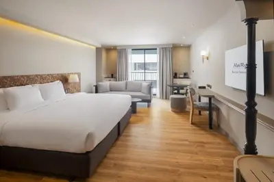 a hotel room with a large bed and a desk at Away Bangkok Sukhumvit in Bangkok