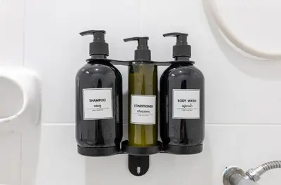 two bottles of soap on a wall in a bathroom at Calmly Stay Ratchada in Bangkok