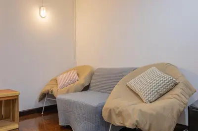 a room with a bed and a couch with pillows at Calmly Stay Ratchada in Bangkok