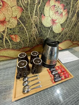 a wooden tray with a coffee pot and spoons at Yotaka Boutique Hotel Bangkok in Bangkok