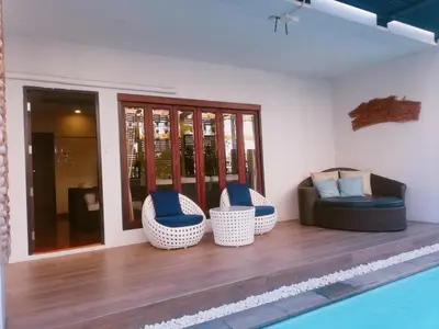 a living room with chairs and a swimming pool at Yotaka Boutique Hotel Bangkok in Bangkok