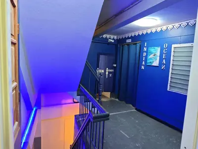 a hallway with blue walls and a blue staircase at latitude 13 Room & breakfast in Bangkok