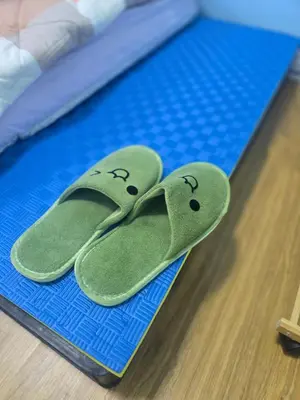 two green flip flops sitting on a blue mat at 214 Lovely apartment with private bathroom and WiFi in Bangkok