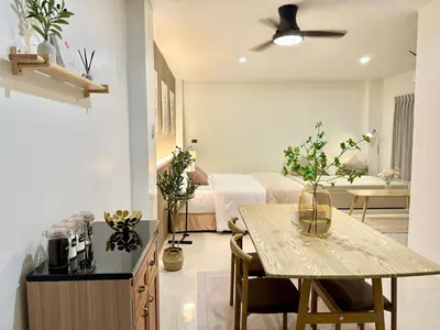 a living room with a bed and a table in a room at Studio Botanica I 2 mins to SRT in Bangkok