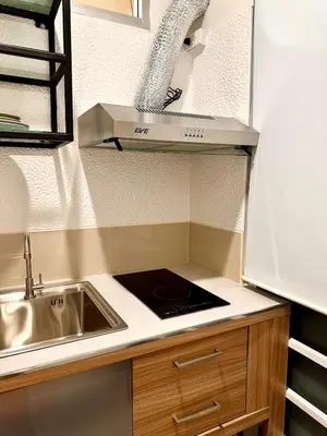 a small kitchen with a sink and a counter top at Studio Botanica I 2 mins to SRT in Bangkok