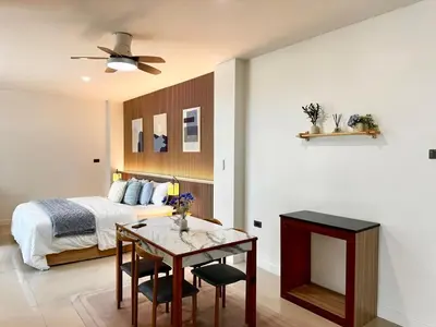 a bedroom with a bed and a table and a table sidx sidx sidx at Indigo Studio 2 mins from SRT Wat Samien Nari in Bangkok