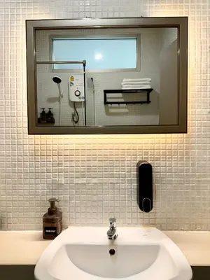 a bathroom with a sink and a mirror and a mirror at Indigo Studio 2 mins from SRT Wat Samien Nari in Bangkok