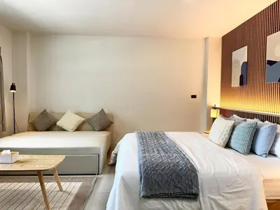 a hotel room with two beds and a table at Indigo Studio 2 mins from SRT Wat Samien Nari in Bangkok