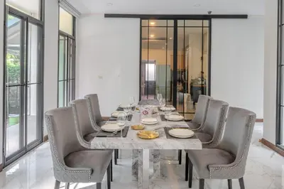 a dining room with a long table and chairs at Sukumvit Pool Villa 5BR 5-7min-walk to Thonglor Sky train in Khlong Toei