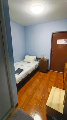 a small room with a bed and a wooden floor at Stay Hostel in Bangkok