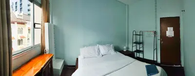 a small bedroom with a bed and a window at Stay Hostel in Bangkok