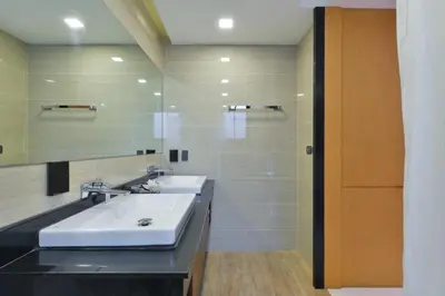 a bathroom with two sinks and a large mirror at Syama Suite Sukhumvit 20 in Bangkok