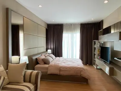 a bedroom with a bed and a tv and a couch at Cozy home near impact arena in Nonthaburi