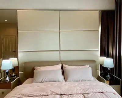 a bedroom with a large bed with two pillows at Cozy home near impact arena in Nonthaburi