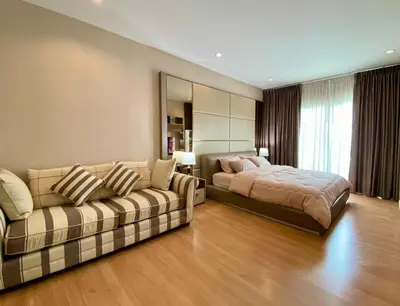 a large bedroom with a bed and a couch at Cozy home near impact arena in Nonthaburi