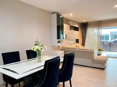 a living room with a table and chairs and a couch at Cozy home near impact arena in Nonthaburi