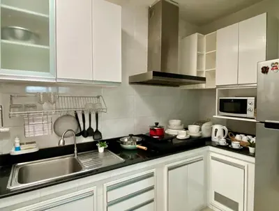 a kitchen with white cabinets and a sink at Cozy home near impact arena in Nonthaburi