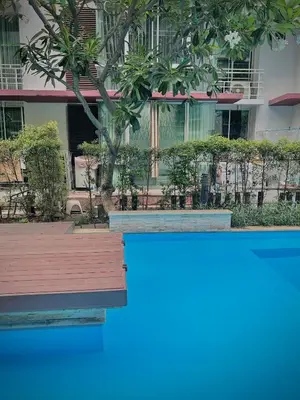 a view of a building with trees and a swimming pool at Condo In Bangkok With Pool and Garden in Sathani Ban Hua Mak