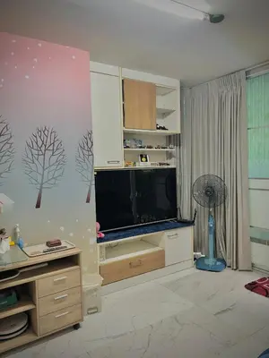 a living room with a flat screen tv and a fan at Condo In Bangkok With Pool and Garden in Sathani Ban Hua Mak