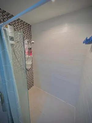 a bathroom with a shower with a toilet and a sink at Condo In Bangkok With Pool and Garden in Sathani Ban Hua Mak