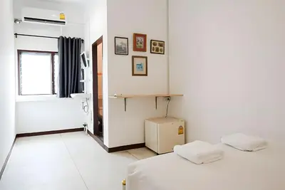 a white room with a bed and a window at XX GO INN Asiatique Bangkok - โกอินน์ เอเชียทีค เจริญกรุง in Bangkok