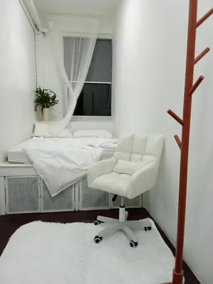 a bedroom with a white chair and a bed at Casita Hostel House Bangkok in Bangkok