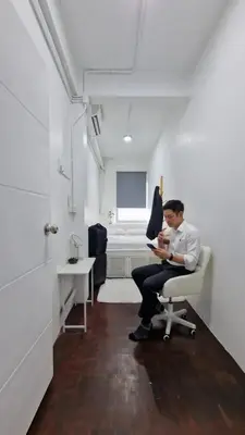 a man sitting in a chair in a room at Casita Hostel House Bangkok in Bangkok