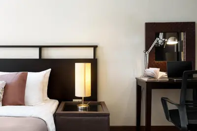 a bedroom with a bed and a desk with a lamp at Mystic Haven King Bed Suite with Balcony & City Views in Khlong Toei