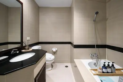 a bathroom with a sink and a toilet and a tub at Mystic Haven King Bed Suite with Balcony & City Views in Khlong Toei